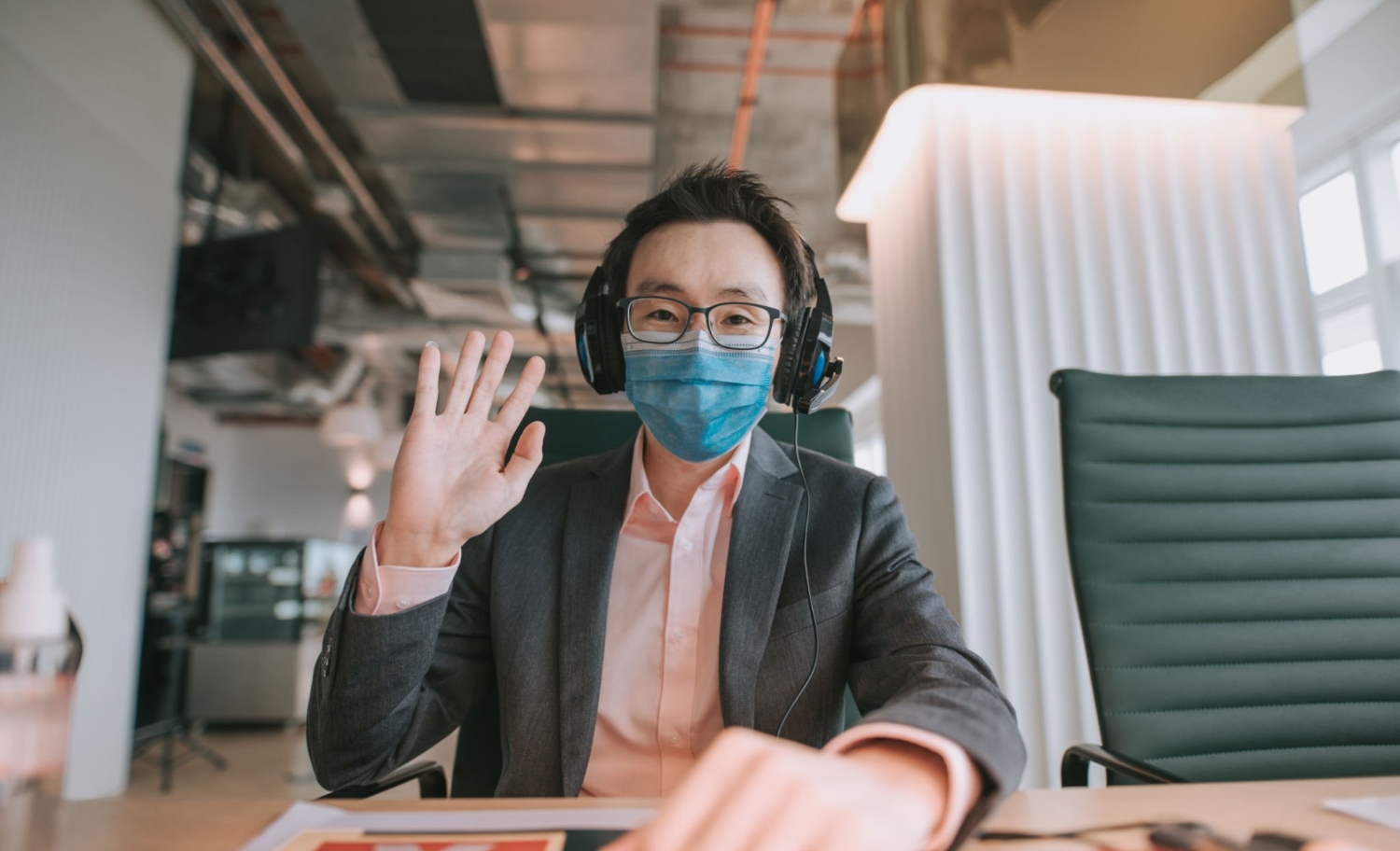 an asian chinese mid adult white collar worker talking to the camera video calling video conference with his business partners with face mask